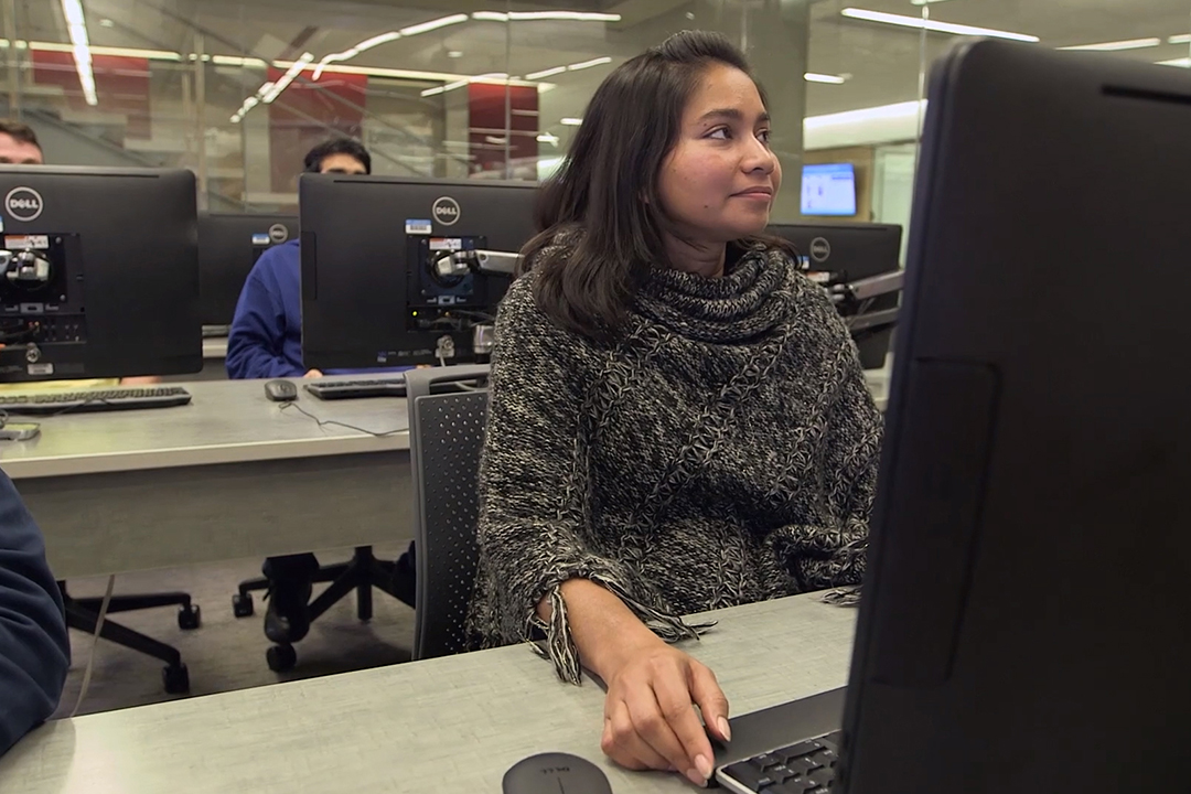 Female student sitting at a computer in a classroom