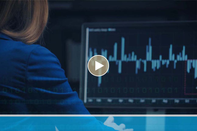 Image of a woman in a blazer entering data at a computer
