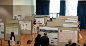 Undergraduate and graduate students displayed poster presentations on large posterboards set up in a ballroom